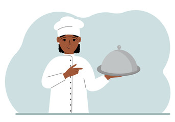 A female chef with a plate covered with a cloche or a tray with a lid.