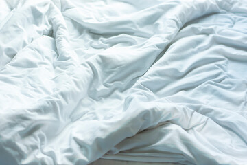 wrinkle messy blanket in bedroom after waking up in the morning from sleeping in a long night details of duvet and blanket an unmade bed in hotel bedroom with white blanket.