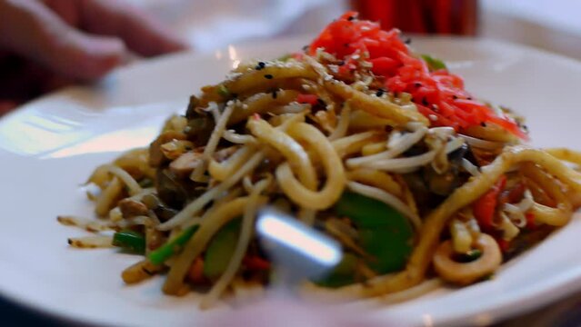 detail of a plate of Asian noodles where we see the sauce, the broth, the noodles and fruits, vegetables, meat and fish tucked into the deep plate in a delicious succulent shoot makes you want to eat