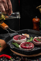 Raw beef meat steak Tenderloin fillet on a cutting board. Beef medallions wrapped in bacon with rosemary and spice. Restaurant menu, dieting, cookbook recipe. place for text