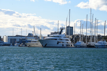 Yacht in La Marina de Valencia, Spain. Luxury yachts and motorboat in yacht club at Mediterranean Sea. Skiff and Sailboat in port. Yachting and sailing sport. Marina parking of boats and yachts.