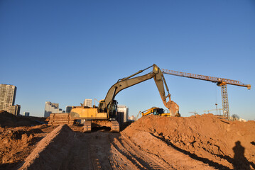 Excavator dig ground at construction site. Dig foundation. Construction of residential buildings,...