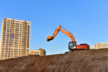 Excavator dig ground at construction site. Dig foundation. Construction of residential buildings,...