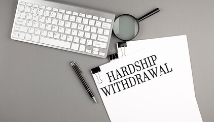 Hardship Withdrawal text on paper with keyboard, magnifier and pen. Business concept