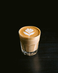 cup of coffee with latte art on black background
