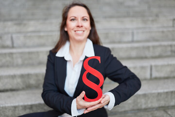 Businesswoman holding paragraph sign as justice and notary symbol