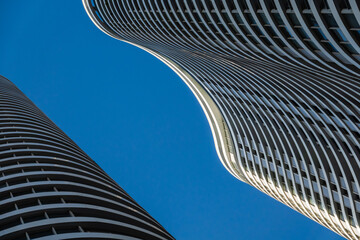 Curvy skyscrapers against blue sky