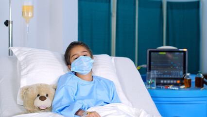 A young schoolgirl suffering from illness - wearing a medical mask  surgical mask  admitted to the hospital  lung disease . A sweet little kid is resting alone in the hospital ward - recovering fro...