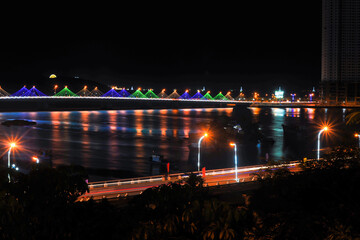 Fototapeta na wymiar view of the night Danang from the top of the hill to the shining bridge, street lights and reflections in the river