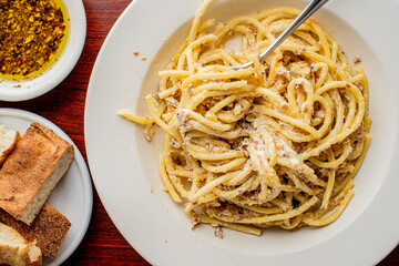 Spaghetti carbonara. Pasta with cured pork, cheese, egg, bacon, pepper and Italian parsley. Classic American or Italian restaurant favorite. Homemade pasta with butter sauce, meat and cheese.