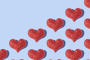 Pattern made from glitter heart shape on colored background with hard shadow. Valentines day minimalistic design