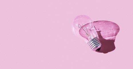 Lamp with hard shadow on pink background. Symbol of creative idea. Light concept