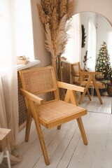 Wooden chair with rattan in room with mirror and Christmas decorations. Winter holiday season.