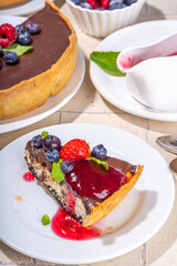 Homemade cheesecake with chocolate and berry. Sweet cottage cheese cake pie with fresh and chocolate topping, classic dessert om beige tiled table copy space