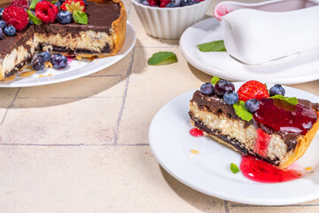 Homemade cheesecake with chocolate and berry. Sweet cottage cheese cake pie with fresh and chocolate topping, classic dessert om beige tiled table copy space