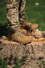 A military man in a special uniform and protective tactical sneakers. Special waterproof sneakers for soldiers in khaki and green