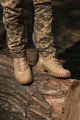 A military man in a special uniform and protective tactical sneakers. Special waterproof sneakers for soldiers in khaki and green