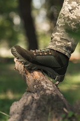 A military man in a special uniform and protective tactical sneakers. Special waterproof sneakers for soldiers in khaki and green