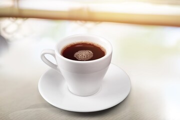 Tasty hot coffee in cup on the table