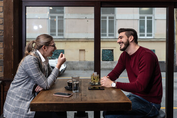 Confident owner of cafe interviewing young specialist. Manager of cafeteria or coffee shop job interview with young male bartender barista or waiter applied for work in the restaurant. Employee hiring