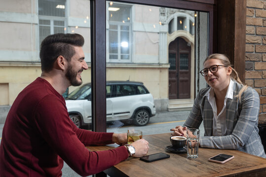 Confident owner of cafe interviewing young specialist. Manager of cafeteria or coffee shop job interview with young male bartender barista or waiter applied for work in the restaurant. Employee hiring - Powered by Adobe