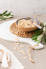 Fototapeta na wymiar Dry thick oat flakes in a ceramic bowl in kitchen counterto. Concept of healthy eating, dieting, dietary fiber