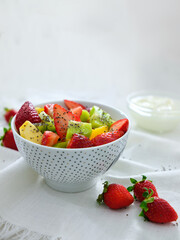 Mix fruit salad with yogurt on white background