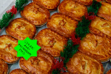 Window display of a British butcher showing steak and mushroom pies, London, UK