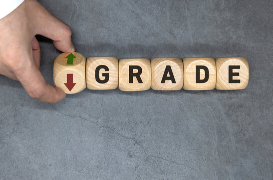The upgrade or downgrade symbol. The entrepreneur turns the wooden cube and replaces the word 'downgrade' with 'upgrade'.