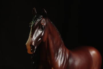 Black toy horse isolated on black background