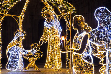 Christmas Manger scene art made many led bright garland lit lamps against old ancient Magdeburg Dom...