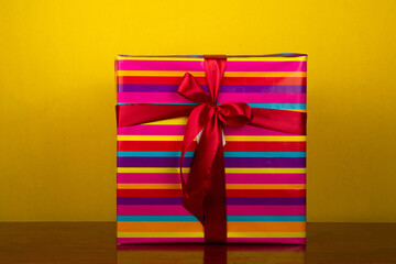 wrapped colorful gift on yellow background