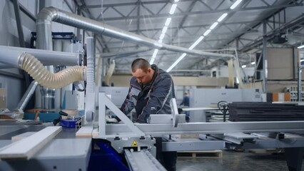 professional woodworker working in industrial furniture production, operator of automated machine