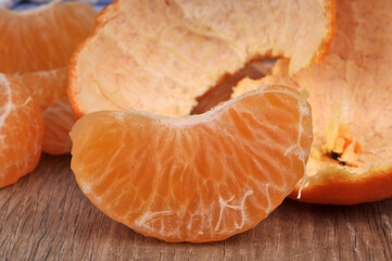 Quartier de mandarine en gros plan avec son écorce au second plan