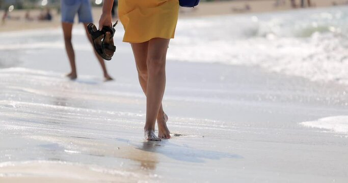 Girl walking along the beach barefoot