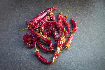 Dried fruits of red hot pepper on a dark gray background close-up.