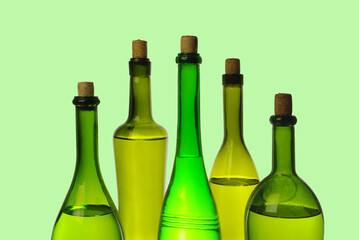 Five wine bottles on a pale green background.