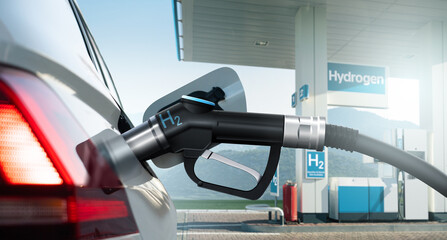 Close up of fuel cell car with connected hydrogen fueling nozzle on a background of H2 filling...