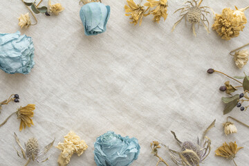 Light blue and yellow various flowers dried flowers decorative frame and burlap background	