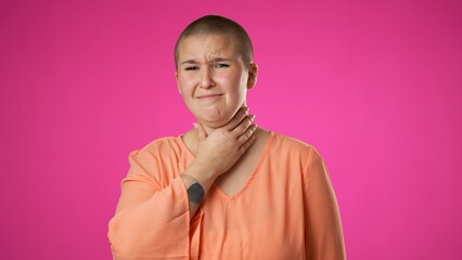 Portrait of gender fluid non binary young hipster woman 20s coughs into hand isolated on pink background studio. Healthy ill sick feel bad disease cold season Epidemic pandemic flu virus concept