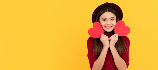 happy cute child with red heart on yellow background. Kid girl portrait with heart love symbol, horizontal poster. Banner header with copy space.