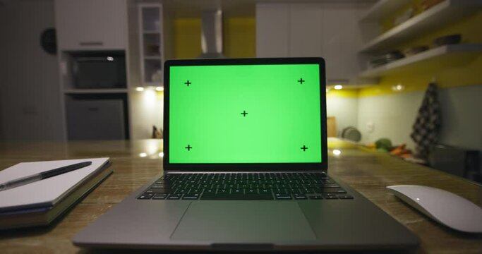 Modern laptop with blank green screen. dolly footage . Home interior modern kitchen background, technology concept 4k video template,rack points with perspective corner pin