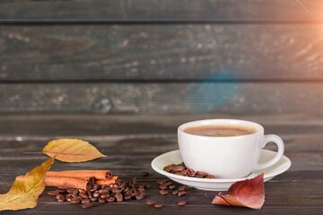 Cozy composition. Hot coffee cup with foliage.