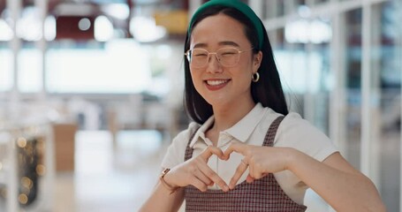 Happy woman, heart and love for creative fashion style in a office with a smile and happiness with hands for support of announcement. Portrait of asian employee with emoji sign for marketing project