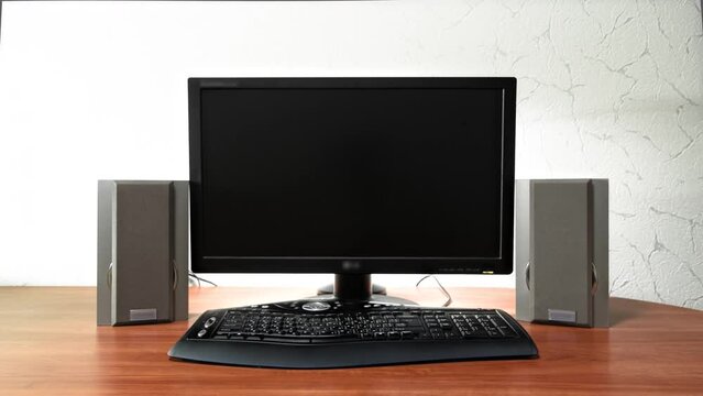 Work desk for digital job with computer, audio speakers and keyboard timelapse hyperlapse. Forward motion to the black screen monitor
