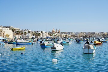 Fototapeta na wymiar Scenic fishing boats in european Marsaxlokk town in Malta