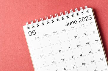 A June 2023 calendar desk for the organizer to plan and reminder isolated on red background.