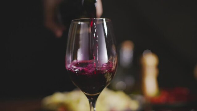 Ta&ccedil;a de vinho sendo servido em slow motion e camera girando. 