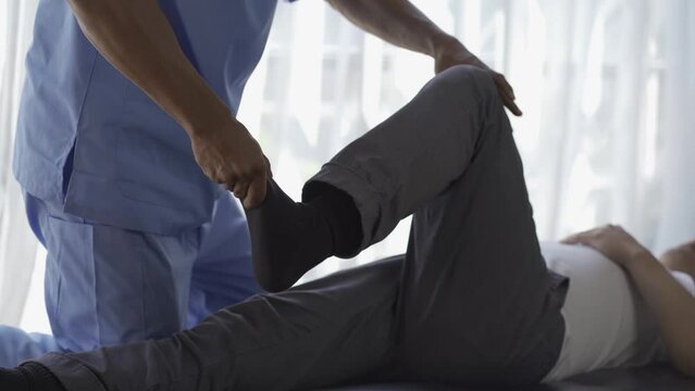 Young man doing physical therapy with trainer Physical therapy and injury rehabilitation with a physical therapist
Helping a male patient at a rehabilitation clinic. High quality 4k video.