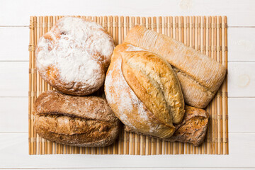 Assortment of freshly baked bread with napkin on rustic table top view. Healthy unleavened bread. French bread